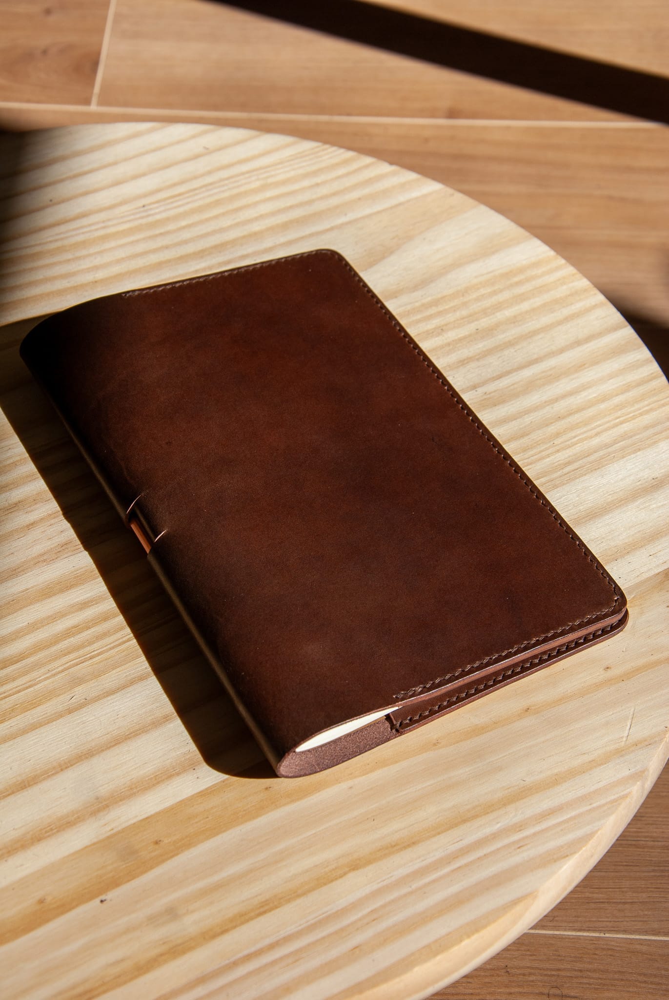 Brown leather notebook on a wooden surface