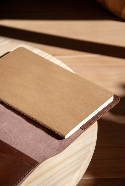 Brown leather-bound notebook on a wooden surface