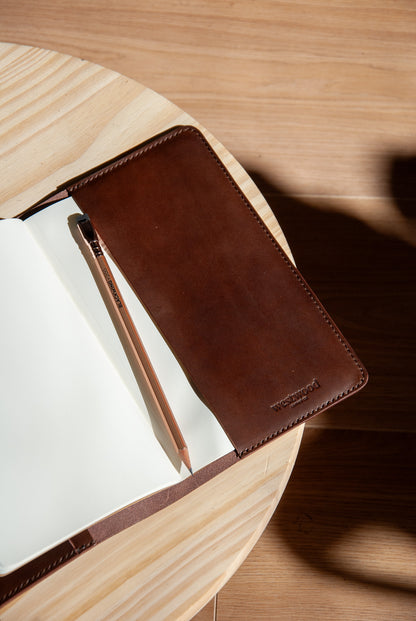 Brown leather notebook cover on a wooden surface