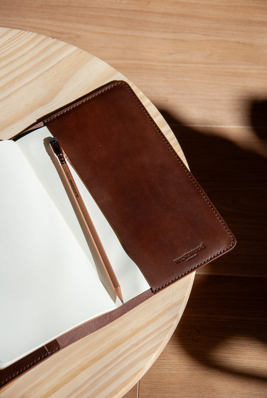Brown leather notebook cover on a wooden surface