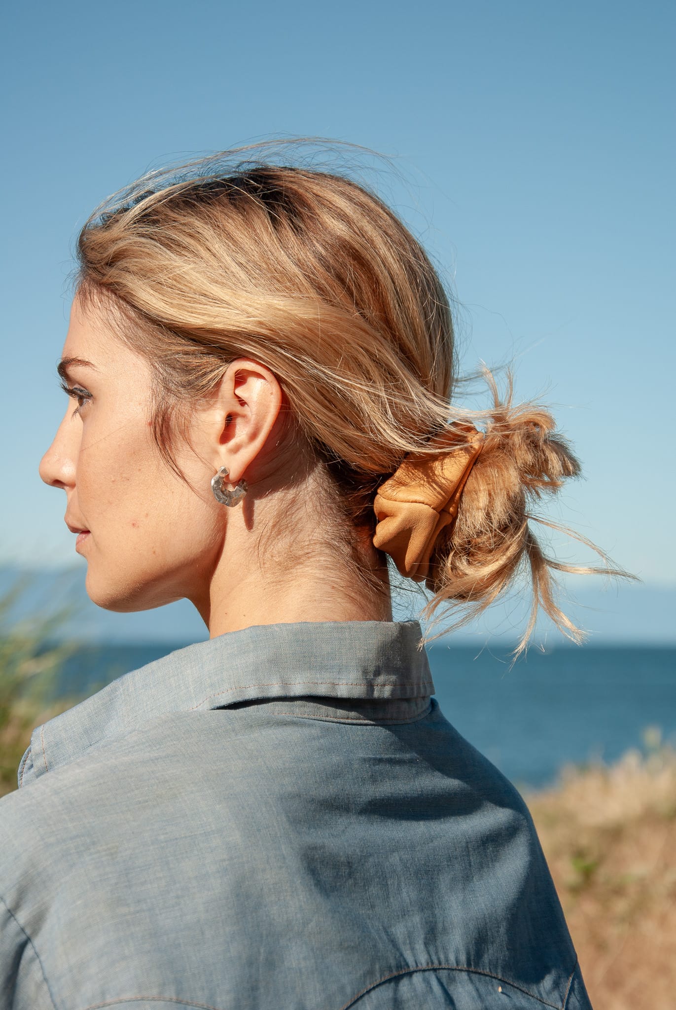 Woman with styled hair looking over a scenic ocean view