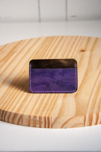 Purple wallet with 'Westwood' branding on a wooden surface