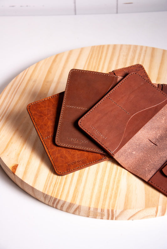 Brown leather card holders on a wooden surface