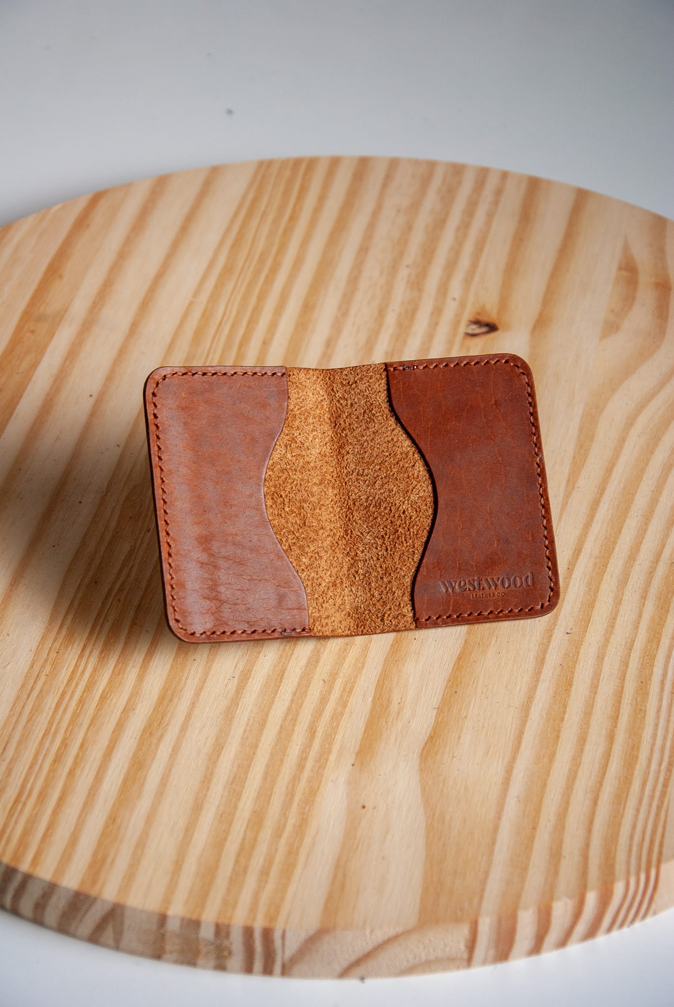 Brown leather cardholder on a wooden surface
