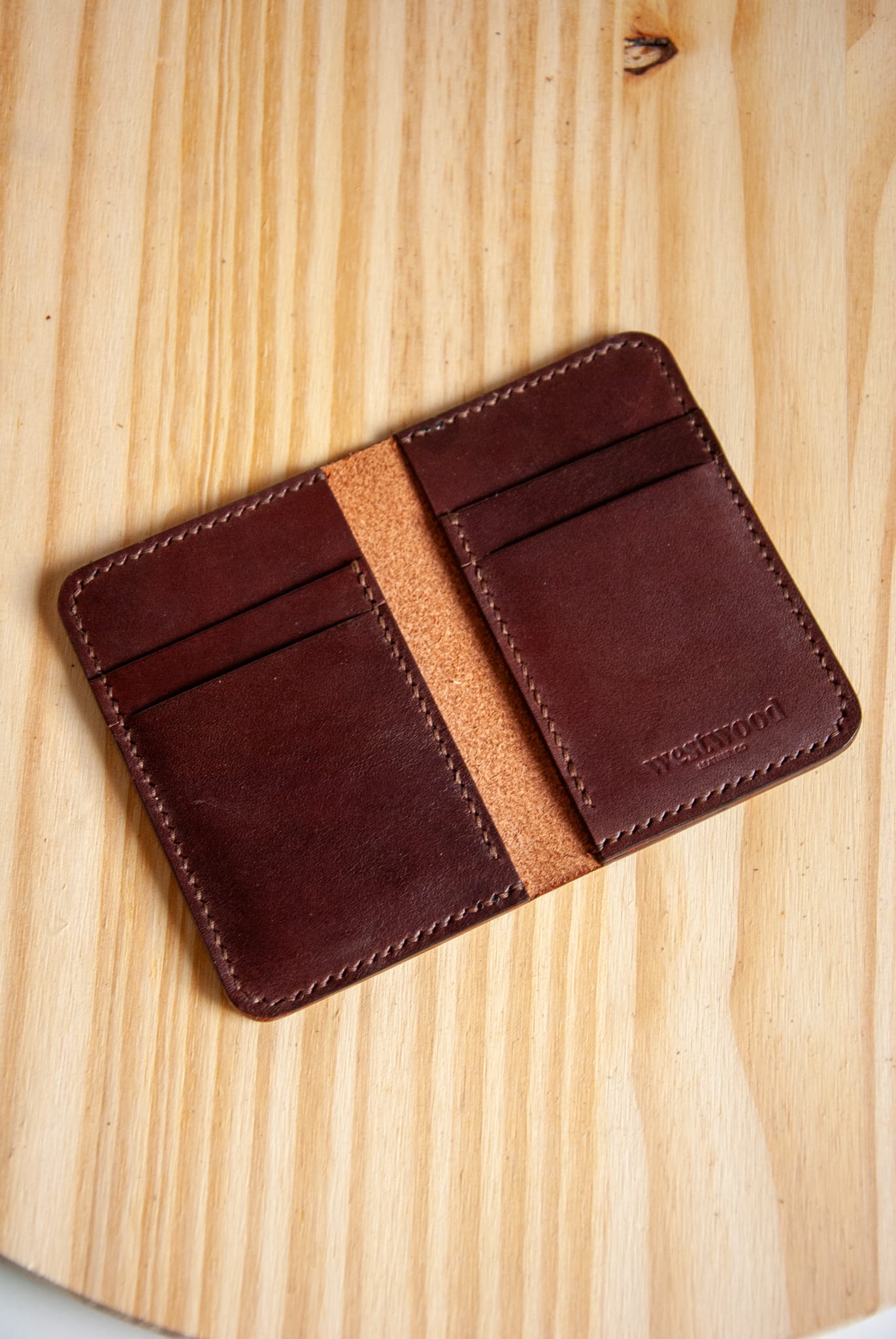 Brown leather wallet on a wooden surface