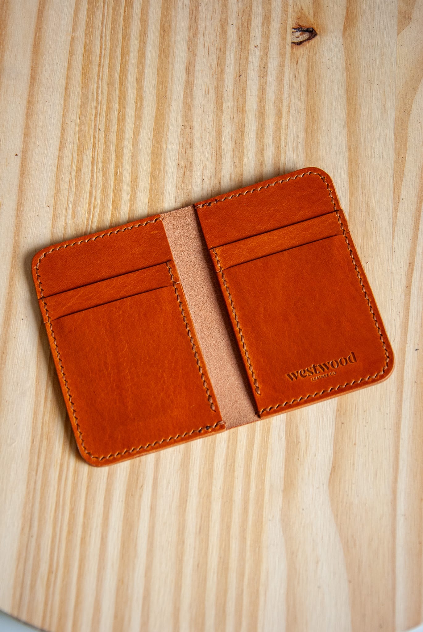 Brown leather cardholder on a wooden surface